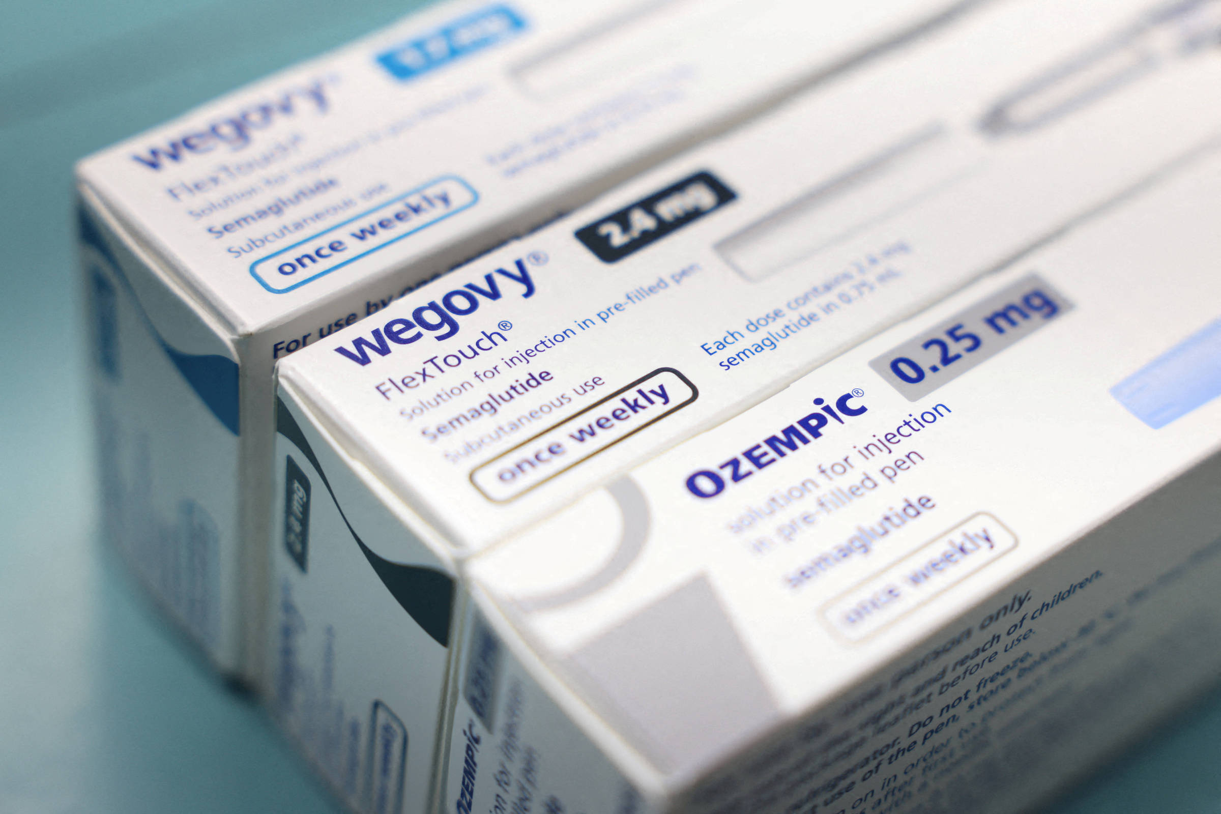 A imagem mostra três embalagens de medicamentos, com destaque para os nomes