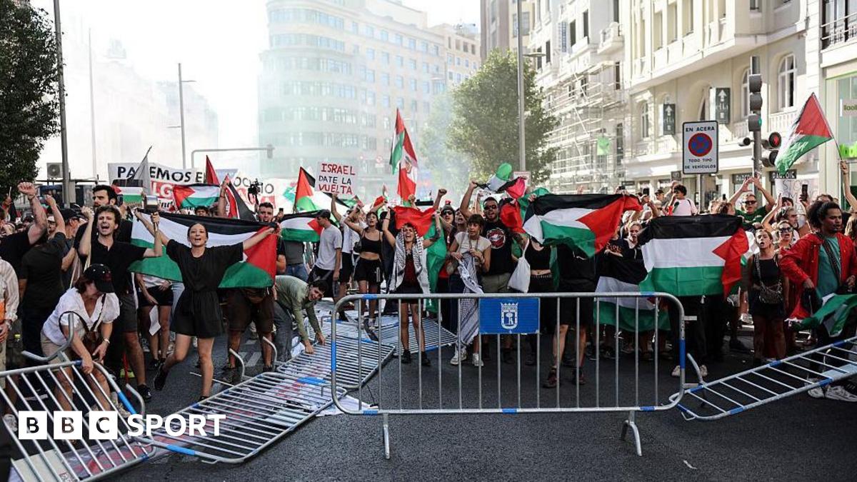 Pro-Palestinian protesters in the middle of the road next to overturned barriers