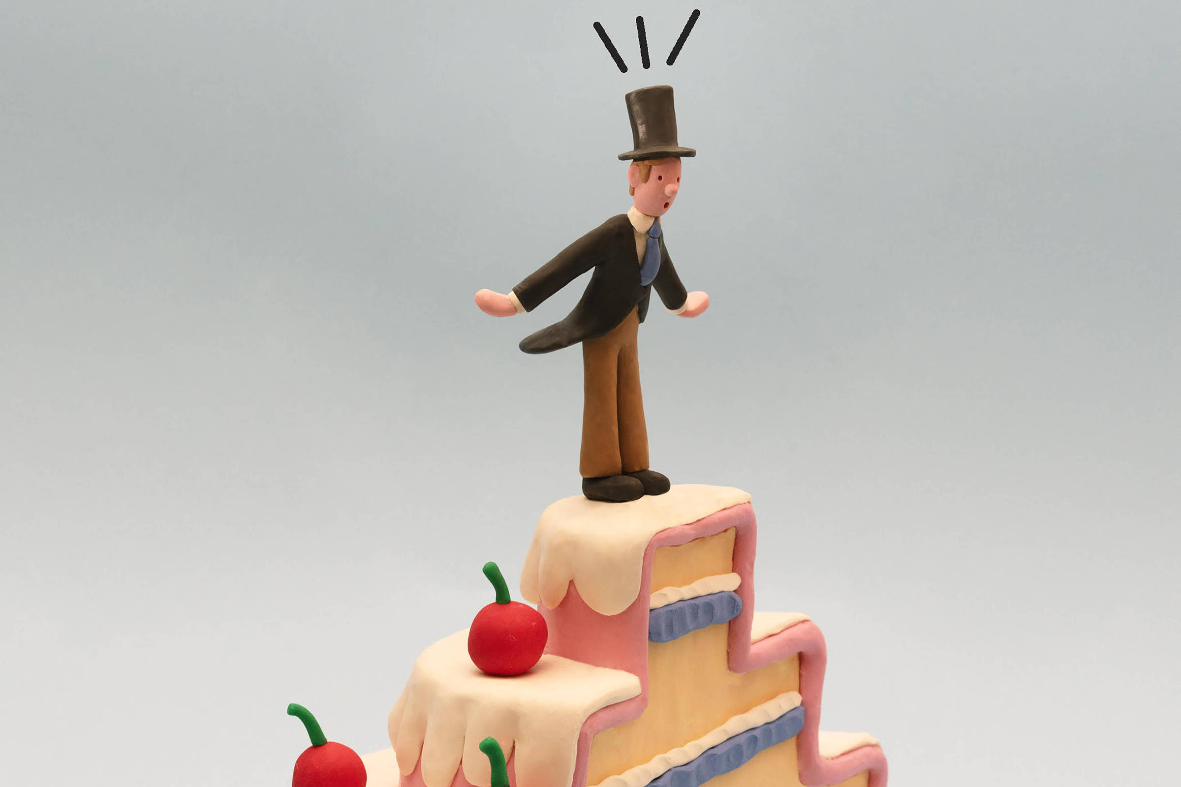 Escultura de bolo em três camadas com cobertura rosa e branca, decorada com três cerejas vermelhas. No topo, figura masculina com cartola preta, casaco preto e calça marrom, com linhas pretas acima da cabeça.