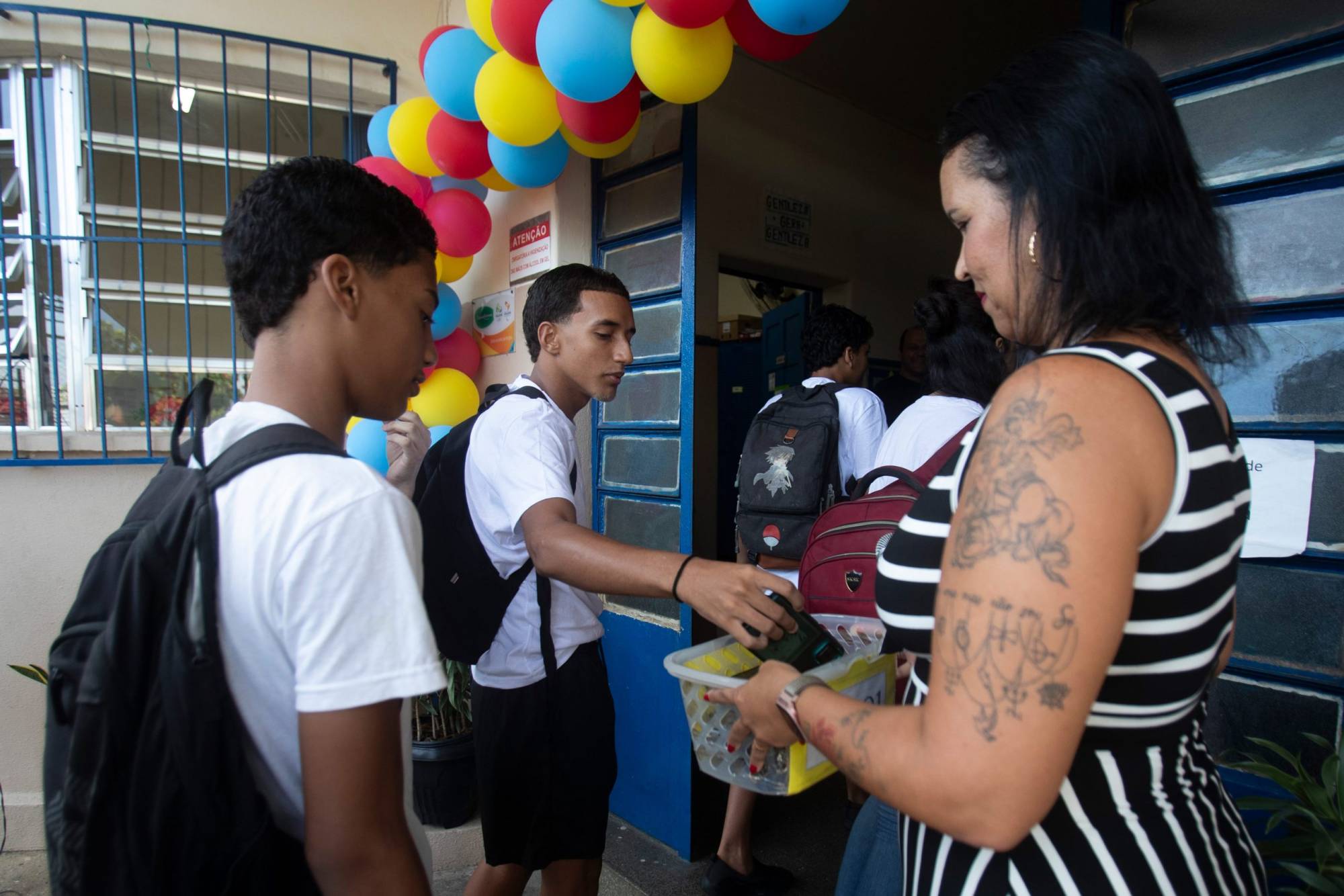 Teacher collects cell phones from students at school.
